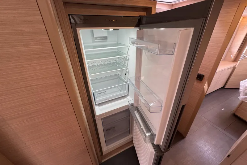  Yacht Photos Pics Open refrigerator inside 2026 Lagoon 55 yacht, showcasing spacious interior and modern design.