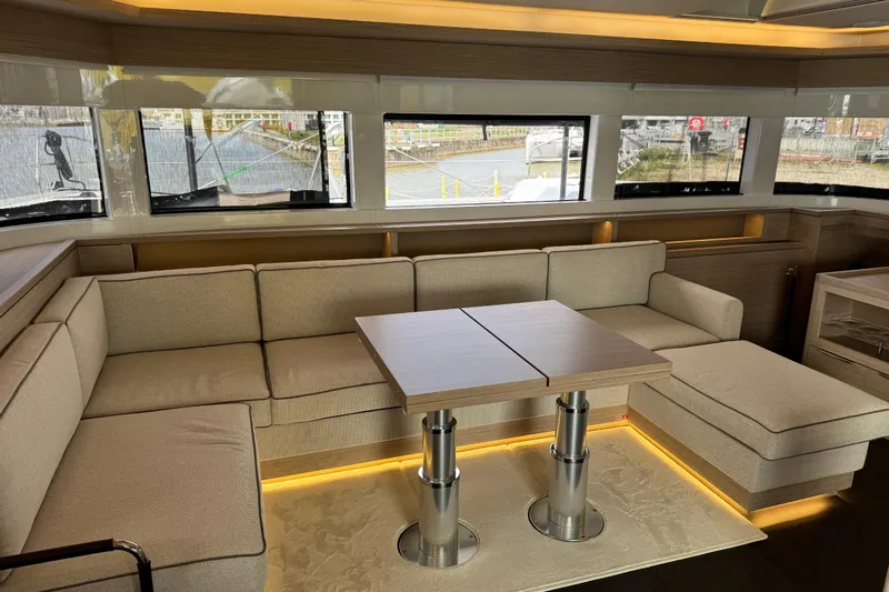  Yacht Photos Pics Luxurious interior of 2026 Lagoon 55 yacht with beige seating and modern table.