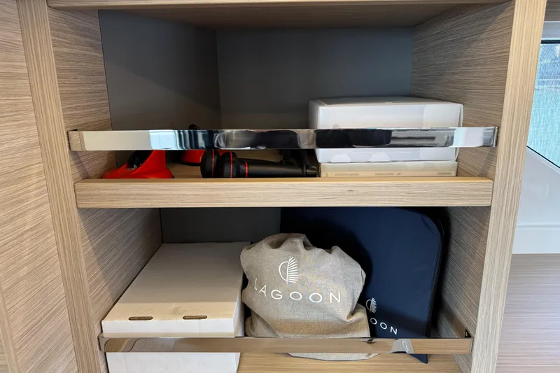  Yacht Photos Pics Storage shelves in a 2026 Lagoon 55 yacht, featuring branded bags and equipment.