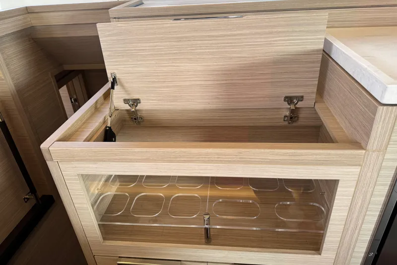  Yacht Photos Pics Modern kitchen storage in 2026 Lagoon 55 yacht, featuring sleek wood finish and glass panel.