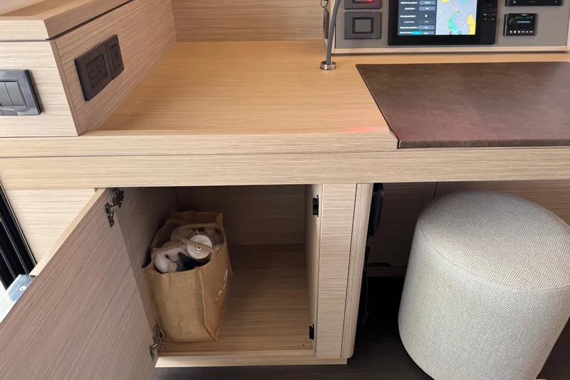  Yacht Photos Pics Modern interior of 2026 Lagoon 55 yacht with open cabinet and control panel.