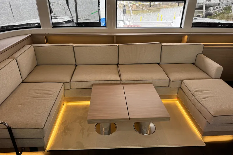  Yacht Photos Pics Luxurious interior of 2026 Lagoon 55 yacht with beige seating and modern table.