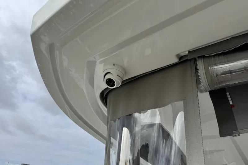  Yacht Photos Pics Security camera on 2026 Lagoon 55 yacht, mounted under canopy with cloudy sky background.