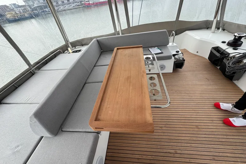  Yacht Photos Pics Luxurious 2026 Lagoon 55 yacht interior with wooden table and cushioned seating.