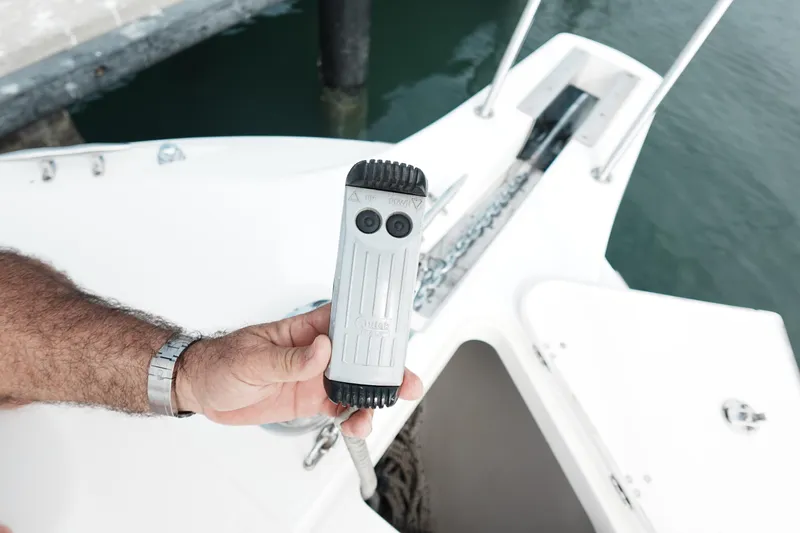  Yacht Photos Pics Hand holding remote control on 2007 Boston Whaler 305 Conquest boat deck.