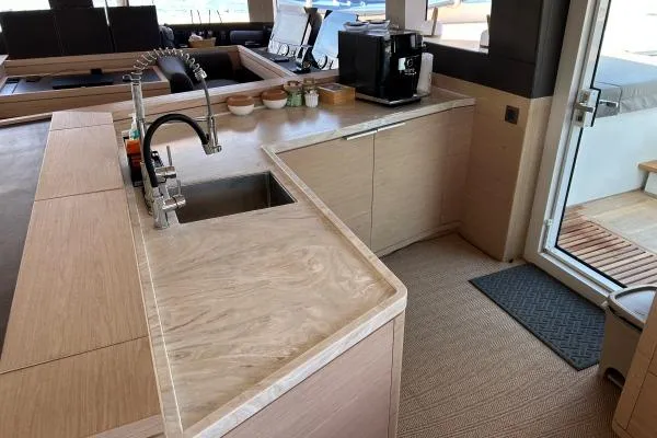 Maty Yacht Photos Pics Modern kitchen interior on 2023 Lagoon Seventy 7 yacht, featuring sleek countertops and appliances.