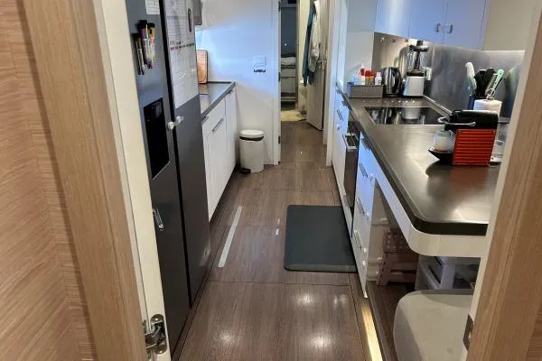 Maty Yacht Photos Pics Modern kitchen interior of 2023 Lagoon Seventy 7 yacht, featuring sleek countertops and appliances.