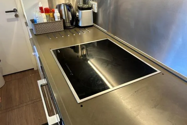 Maty Yacht Photos Pics Modern kitchen countertop with induction cooktop on Lagoon Seventy 7 yacht, 2023 model.