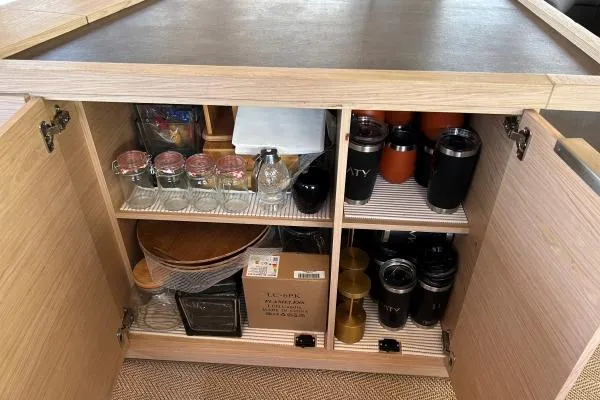 Maty Yacht Photos Pics Open cabinet with organized kitchenware on a 2023 Lagoon Seventy 7 yacht.