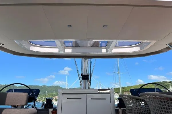 Maty Yacht Photos Pics 2023 Lagoon Seventy 7 yacht cockpit with dual steering wheels and scenic marina view.