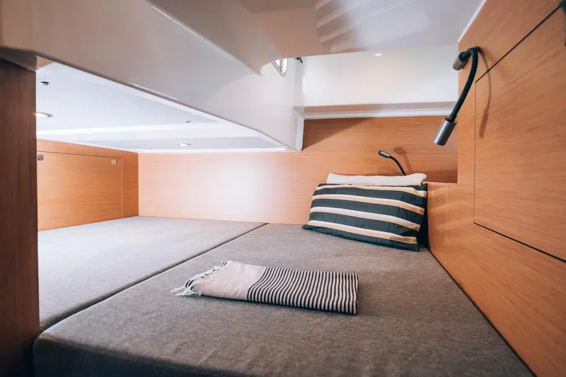  Yacht Photos Pics 2023 Beneteau Flyer 10 cabin interior with cozy bed and striped pillow.