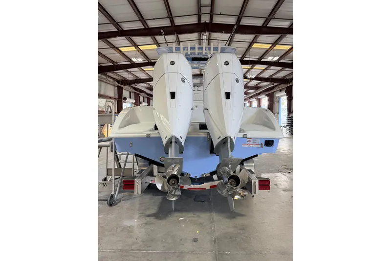  Yacht Photos Pics 2026 Yellowfin 32 Offshore boat with dual outboard engines in a warehouse setting.
