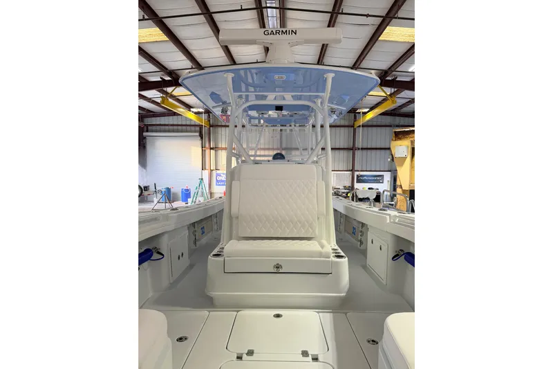  Yacht Photos Pics 2026 Yellowfin 32 Offshore boat interior with Garmin equipment in a warehouse setting.