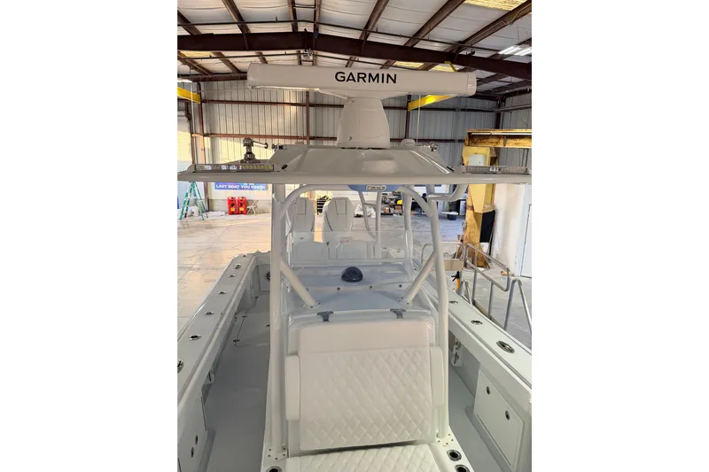  Yacht Photos Pics 2026 Yellowfin 32 Offshore boat with Garmin radar in a warehouse setting.