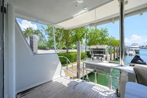 Pomboo Yacht Photos Pics 1998 Hatteras 70 Cockpit Motor Yacht docked, featuring spacious deck and outdoor grill.