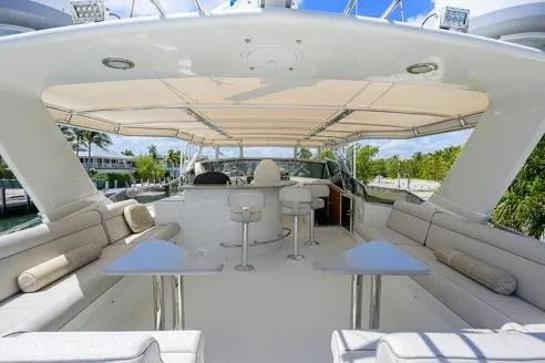 Pomboo Yacht Photos Pics Luxurious 1998 Hatteras 70 Cockpit Motor Yacht with spacious outdoor seating and bar area.