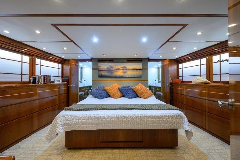 Pomboo Yacht Photos Pics Luxurious bedroom interior of 1998 Hatteras 70 Cockpit Motor Yacht with elegant wood finishes.