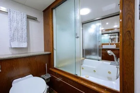 Pomboo Yacht Photos Pics Bathroom interior of 1998 Hatteras 70 Cockpit Motor Yacht with shower and wooden accents.