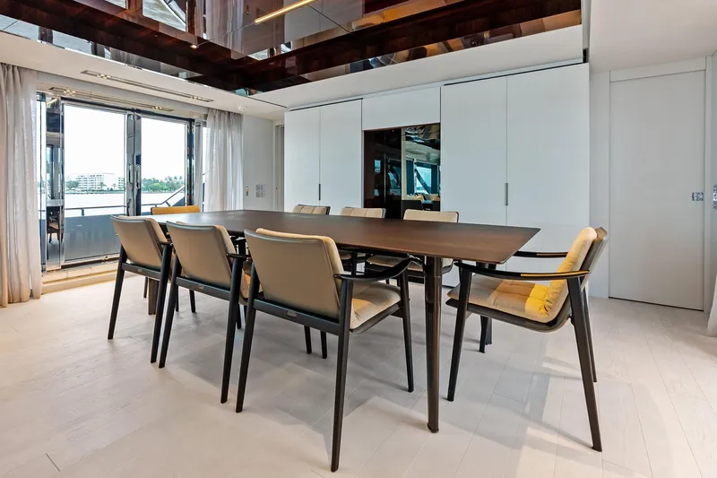 Riva Royale Yacht Photos Pics Luxurious dining area on 2023 Riva 110' Dolcevita yacht with elegant table and chairs.
