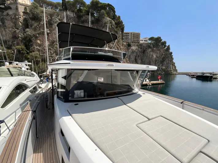  Yacht Photos Pics Pardo Yachts 60 E 2020 model docked by rocky coastline under clear blue sky.