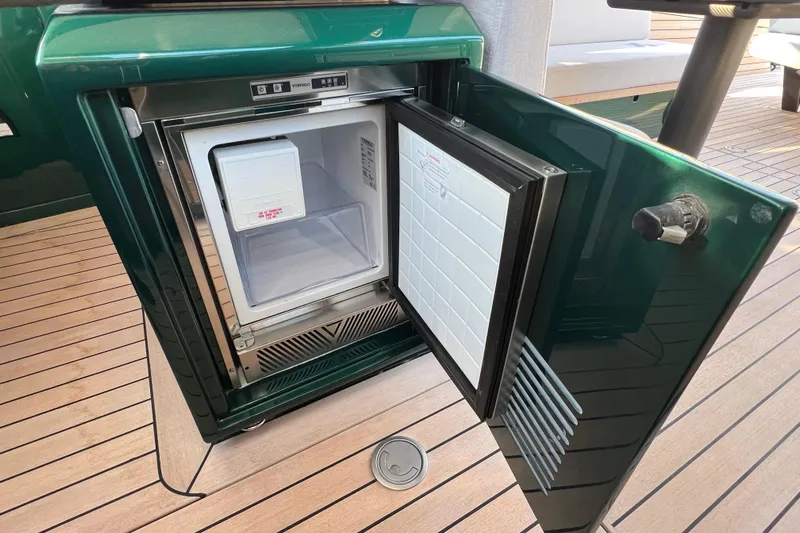  Yacht Photos Pics Open mini fridge on 2024 Wally Tender 43 X yacht, showcasing sleek design and wooden deck.