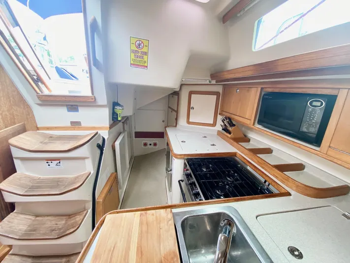 Licentia Yacht Photos Pics Interior of 2008 Catalina 42 MkII yacht kitchen with stove, sink, and microwave.