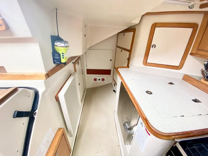 Licentia Yacht Photos Pics Interior of 2008 Catalina 42 MkII sailboat, featuring compact kitchen area with storage cabinets.