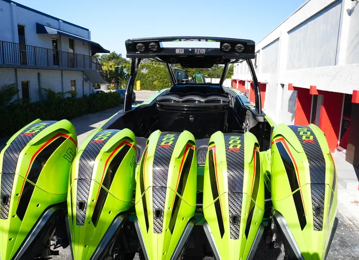  Yacht Photos Pics 2022 MTI 50V Center Console with vibrant green quad engines, docked outdoors.