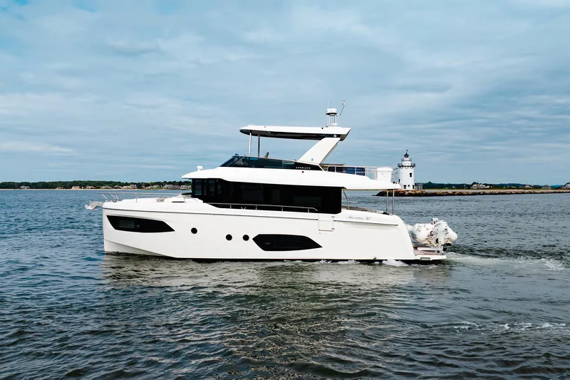 The Transporter Yacht Photos Pics 2023 Absolute 52 Navetta yacht cruising on open water with lighthouse in background.