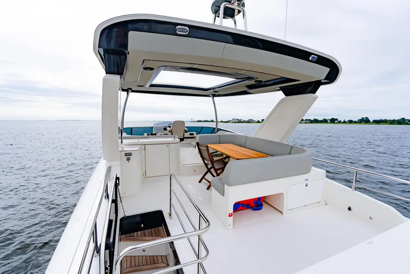 The Transporter Yacht Photos Pics Luxurious 2023 Absolute 52 Navetta yacht with spacious deck and seating area on open water.