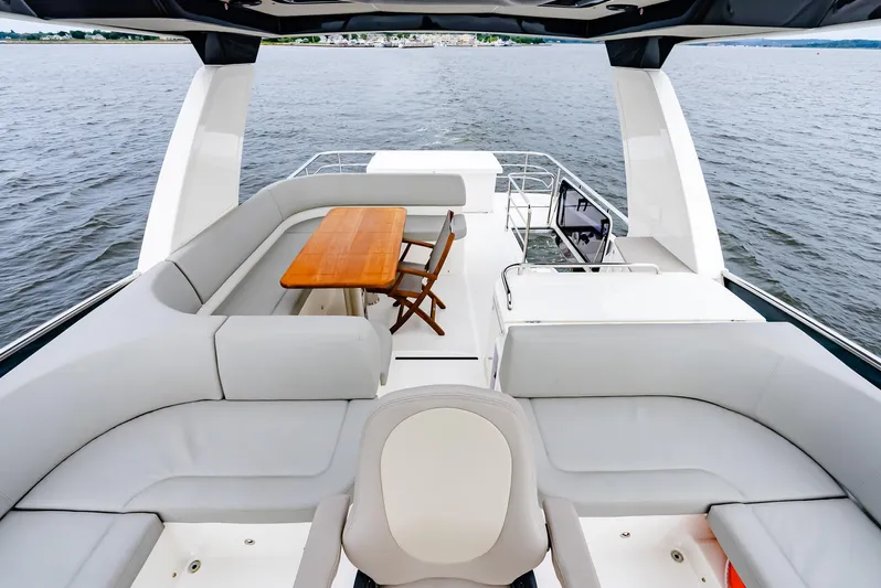 The Transporter Yacht Photos Pics Luxurious 2023 Absolute 52 Navetta yacht deck with seating and dining area on the water.
