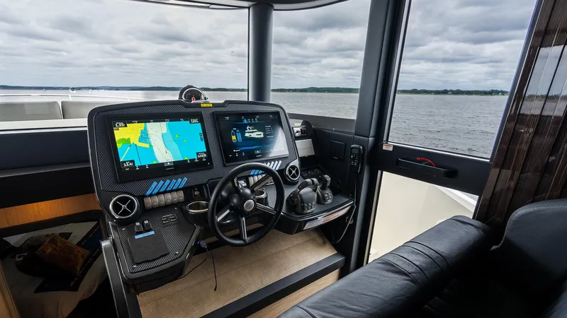 The Transporter Yacht Photos Pics Helm of 2023 Absolute 52 Navetta yacht with navigation screens and steering wheel.