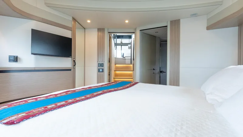 The Transporter Yacht Photos Pics Luxurious bedroom interior of 2023 Absolute 52 Navetta yacht with modern decor and TV.