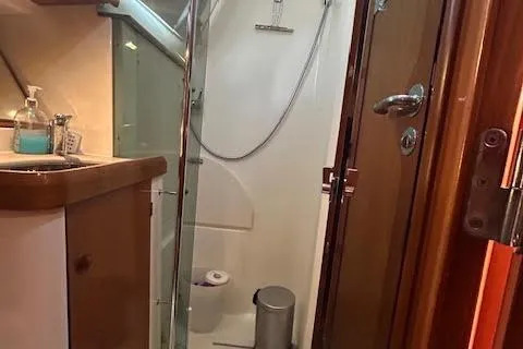 Nonna Yacht Photos Pics 2005 Jeanneau Deck Salon 43 bathroom with shower, sink, and wooden cabinetry.