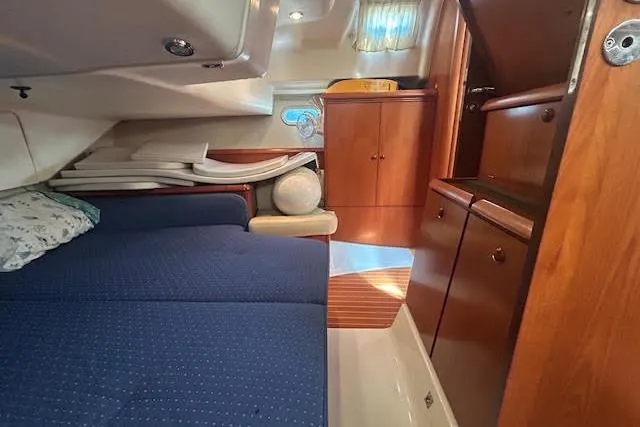 Nonna Yacht Photos Pics Interior of 2005 Jeanneau Deck Salon 43 with blue upholstery and wooden cabinetry.