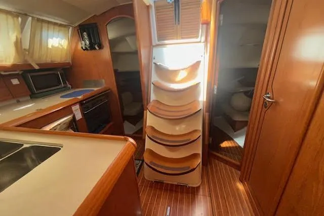 Nonna Yacht Photos Pics Interior of 2005 Jeanneau Deck Salon 43 yacht with wooden cabinetry and modern kitchen.