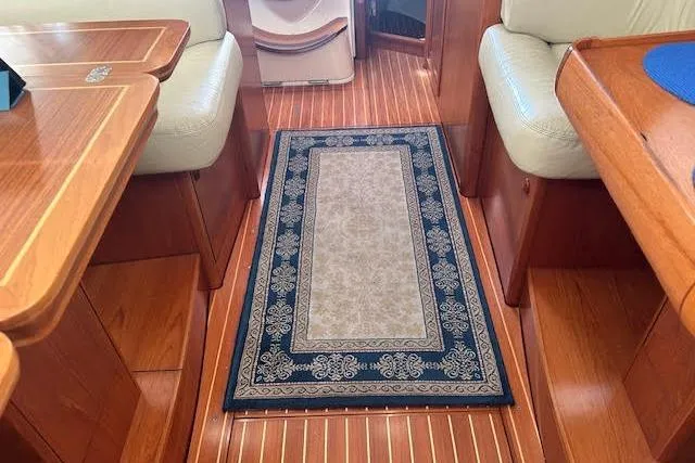 Nonna Yacht Photos Pics Interior of 2005 Jeanneau Deck Salon 43 with elegant wood finish and decorative rug.