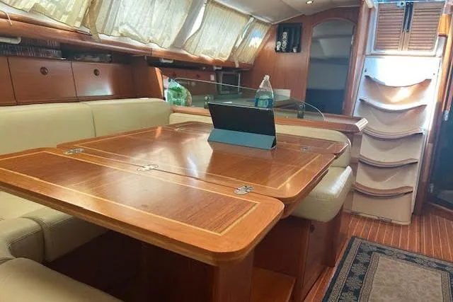 Nonna Yacht Photos Pics Interior of 2005 Jeanneau Deck Salon 43 with elegant wood table and seating.