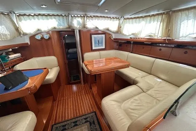 Nonna Yacht Photos Pics Luxurious interior of 2005 Jeanneau Deck Salon 43 with elegant wood and leather seating.