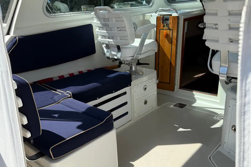 Eventide Yacht Photos Pics Interior of a 2007 Back Cove 29 boat with blue seating and white captain's chair.