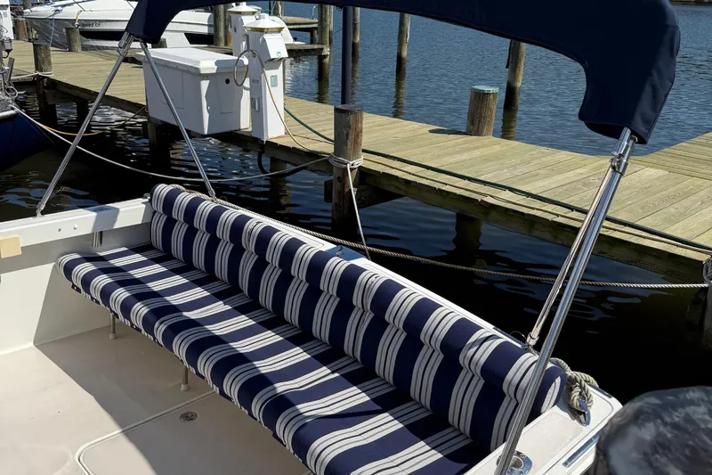 Eventide Yacht Photos Pics 2007 Back Cove 29 boat with striped seating and canopy at a dock.