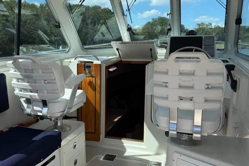 Eventide Yacht Photos Pics Interior of 2007 Back Cove 29 boat with helm chairs and navigation equipment.