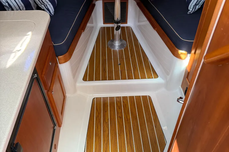 Eventide Yacht Photos Pics 2007 Back Cove 29 interior with wood flooring and navy cushions.