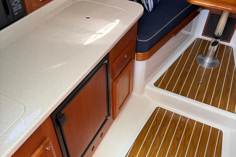 Eventide Yacht Photos Pics 2007 Back Cove 29 interior with wood flooring, compact kitchen, and seating area.
