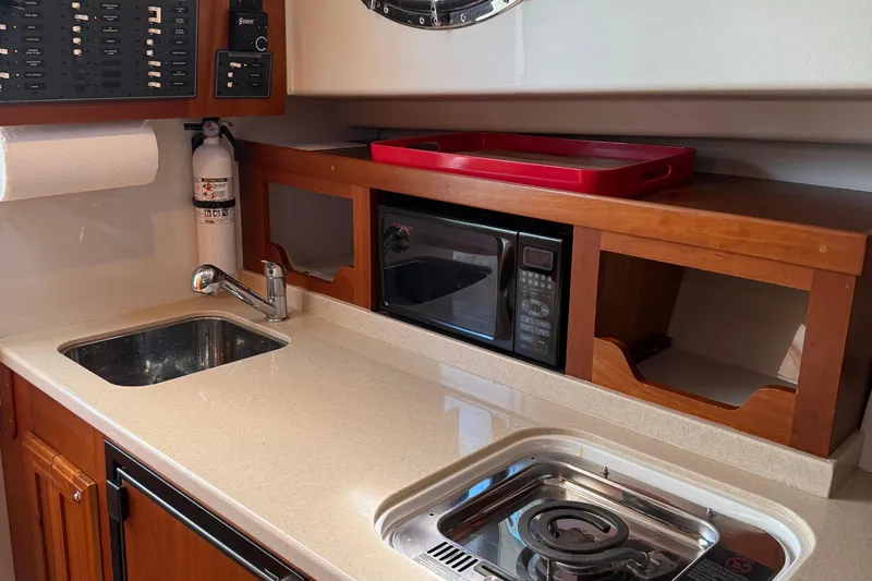 Eventide Yacht Photos Pics 2007 Back Cove 29 yacht kitchen with sink, stove, microwave, and storage.