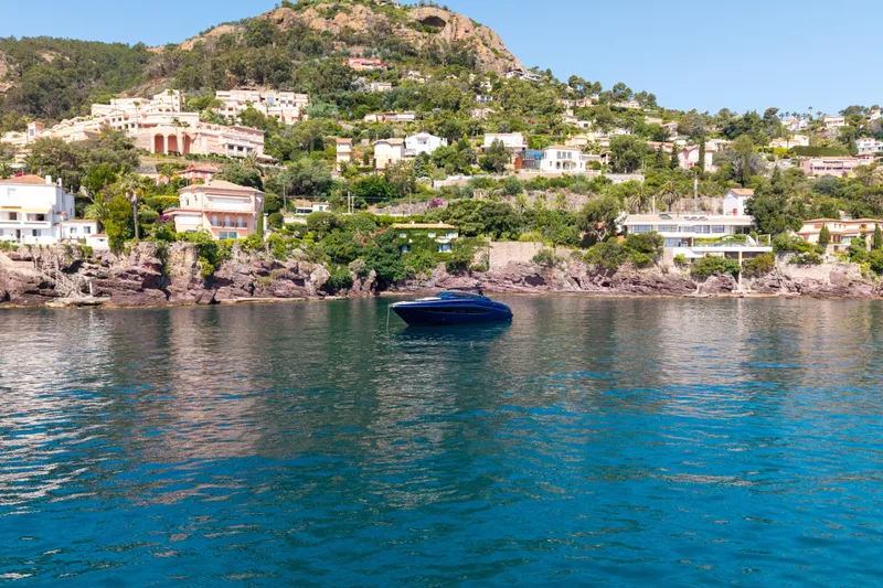  Yacht Photos Pics 2015 Riva 63 Virtus yacht on serene coastal waters with hillside villas in the background.