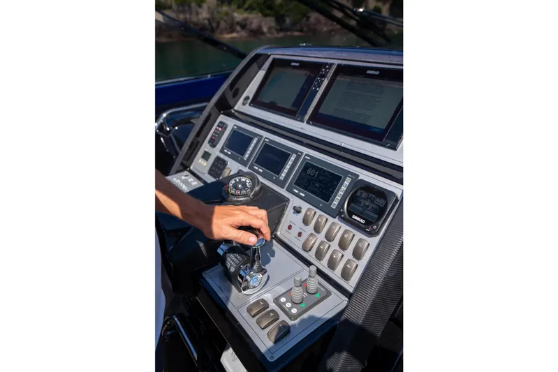 Yacht Photos Pics Hand operating controls on 2015 Riva 63 Virtus yacht dashboard with navigation screens.