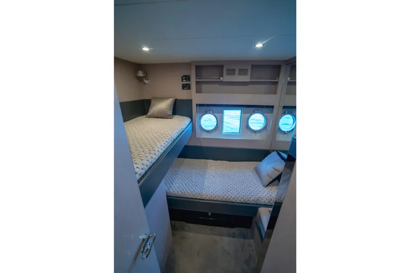 Yacht Photos Pics Interior cabin of 2015 Riva 63 Virtus yacht with bunk beds and porthole windows.