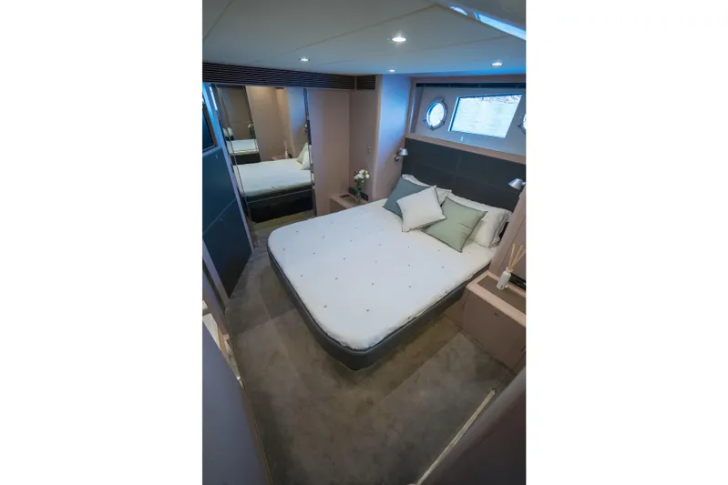  Yacht Photos Pics Luxurious bedroom interior of 2015 Riva 63 Virtus yacht with modern decor and porthole windows.