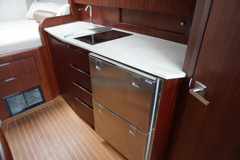  Yacht Photos Pics Luxurious 2021 Jupiter 41 SB yacht interior with modern kitchenette and stainless steel appliances.